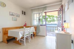 a dining room with a table and a view of the ocean at Apartment Prizba 10063c in Prizba