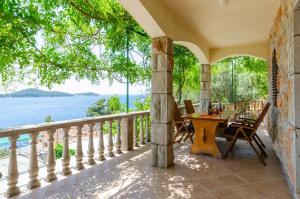 an outdoor patio with a table and chairs and the water at Apartments by the sea Prizba, Korcula - 10063 in Prizba