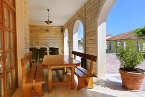 a patio with a wooden table and a bench at Apartment Duce 10303a in Duće