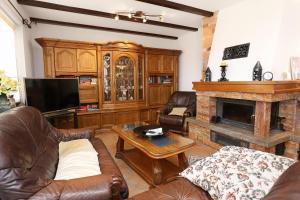 sala de estar con muebles de cuero y chimenea en Apartment Duce 10303a en Duće