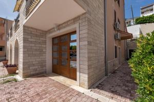 a house with a wooden door on a street at Apartments and rooms with parking space Duce, Omis - 10303 in Duće