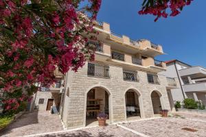a building with pink flowers in front of it at Apartments and rooms with parking space Duce, Omis - 10303 in Duće
