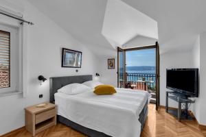 a bedroom with a bed and a flat screen tv at Apartments and rooms with parking space Duce, Omis - 10303 in Duće