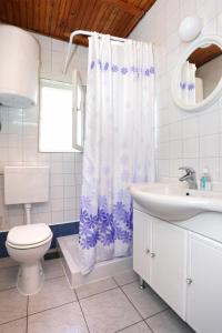 a bathroom with a toilet sink and a shower curtain at Apartments with a parking space Orebic, Peljesac - 10102 in Orebić