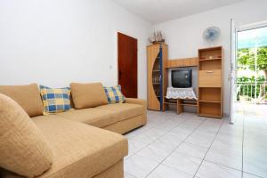 a living room with a couch and a tv at Apartments with a parking space Orebic, Peljesac - 10102 in Orebić