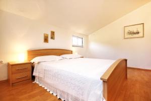 a bedroom with a large white bed and a window at Apartment Prizba 10061a in Prizba