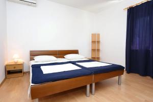um quarto com uma cama com um cobertor azul em Apartment Orebic 10102c em Orebić