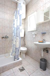 uma casa de banho com um lavatório de WC e uma cortina de chuveiro em Apartment Orebic 10102c em Orebić