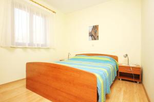 a bedroom with a bed with a striped blanket on it at Apartments with a parking space Orebic, Peljesac - 10157 in Orebić