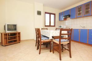 a kitchen with a table and chairs and a tv at Apartments with a parking space Orebic, Peljesac - 10157 in Orebić