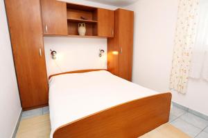 1 dormitorio pequeño con 1 cama con armarios de madera en Apartments by the sea Viganj, Peljesac - 10140, en Viganj