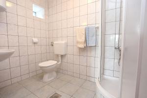 y baño blanco con aseo y ducha. en Apartments by the sea Viganj, Peljesac - 10140, en Viganj