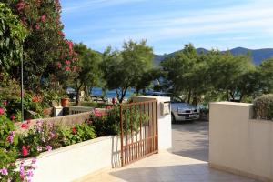 una puerta en un jardín con flores y árboles en Apartments by the sea Viganj, Peljesac - 10140, en Viganj