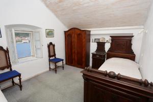 a bedroom with a bed and two chairs and a window at Secluded fisherman's cottage Ston - Supavao, Peljesac - 9485 in Ston