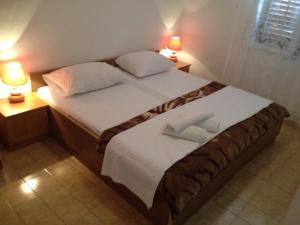 ein Schlafzimmer mit einem Bett mit zwei Kissen und zwei Lampen in der Unterkunft Apartments by the sea Cove Pjestata, Peljesac - 10236 in Blaževo