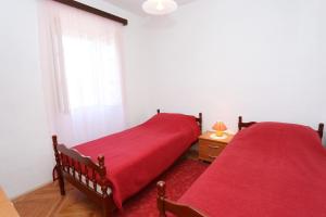 dwa łóżka w sypialni z czerwoną pościelą w obiekcie Holiday house with a parking space Zrnovo, Korcula - 10030 w Korčuli