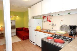 a kitchen with a white refrigerator and a stove top oven at Apartments by the sea Korcula - 10041 in Korčula