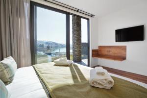 um quarto de hotel com uma cama com uma grande janela em Grand Suites Lake Tekapo em Lake Tekapo