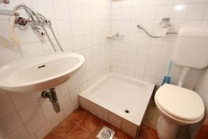 een witte badkamer met een wastafel en een toilet bij Apartments with a parking space Orebic, Peljesac - 10089 in Orebić