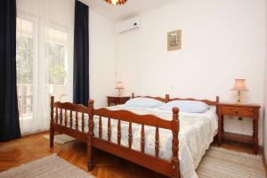 1 dormitorio con cama de madera y ventana en Apartments and rooms with parking space Orebic, Peljesac - 10085, en Orebić 29 fotos más