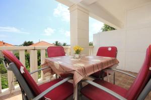 a wooden table with red chairs on a balcony at Apartments with parking space Orebic, Peljesac - 10088 in Orebić