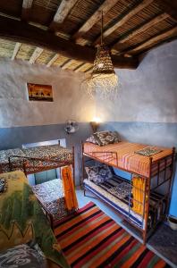 Habitación con 2 literas y lámpara de araña. en Hike and Chill Homestay en Tinerhir