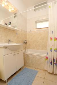 ein Bad mit einem Waschbecken und einem Duschvorhang in der Unterkunft Apartments with a parking space Orebic, Peljesac - 10103 in Orebić