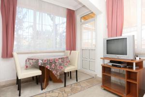 ein kleines Esszimmer mit einem Tisch und einem TV in der Unterkunft Apartments with a parking space Orebic, Peljesac - 10103 in Orebić