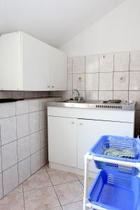 uma cozinha com armários brancos, um lavatório e uma máquina de lavar louça em Apartments by the sea Sreser, Peljesac - 10105 em Janjina