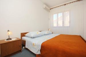 a white bedroom with a bed and a window at Apartments with a parking space Orebic, Peljesac - 10159 in Orebić