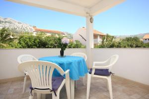 a table and chairs on a balcony with a blue table and chairs at Apartments with parking space Orebic, Peljesac - 10159 in Orebić