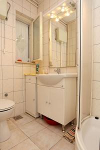 a bathroom with a sink and a toilet and a mirror at Apartments with a parking space Trpanj, Peljesac - 10111 in Trpanj