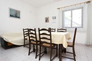 ein Esszimmer mit einem Tisch, Stühlen und einem Bett in der Unterkunft Apartments by the sea Sreser, Peljesac - 10227 in Janjina