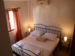 a bedroom with a bed with two pillows and a window at Apartments with WiFi Trpanj, Peljesac - 10121 in Trpanj