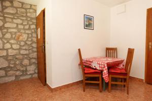 a table and chairs in a room with a stone wall at Apartments with WiFi Trpanj, Peljesac - 10121 in Trpanj