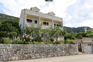 ein Gebäude auf einer Steinmauer in der Unterkunft Apartment Viganj 10116c in Viganj