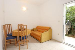a living room with a table and a chair and a couch at Apartment Viganj 10116c in Viganj