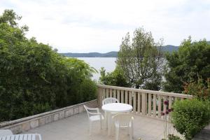 een tafel en stoelen op een balkon met uitzicht op het water bij Apartment Viganj 10116c in Viganj +16 foto's