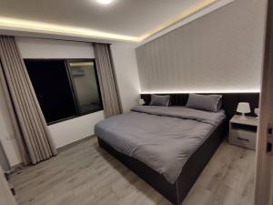 - une chambre avec un grand lit et une fenêtre dans l'établissement 45m luxury room royal view near all services, à Amman