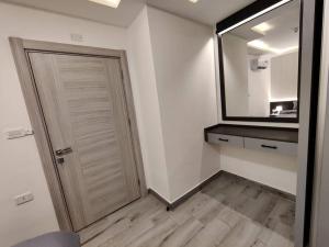 um quarto branco com uma porta e um espelho em 45m luxury room royal view near all services em Amã