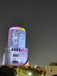 un grand bâtiment blanc avec une lumière colorée dans l'établissement 45m luxury room royal view near all services, à Amman