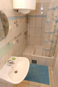 a bathroom with a sink and a shower and a tub at Apartments by the sea Viganj, Peljesac - 10116 in Viganj
