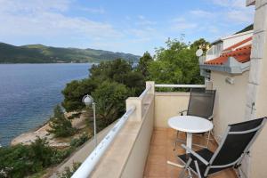 einen Balkon mit 2 Stühlen und einem Tisch auf einem Gebäude in der Unterkunft Apartments by the sea Viganj, Peljesac - 10116 in Viganj