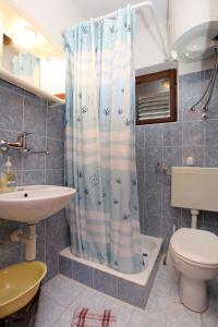 uma casa de banho com uma cortina de chuveiro e um WC em Apartments with a parking space Trpanj, Peljesac - 10148 em Trpanj
