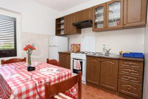 uma cozinha com uma mesa com uma toalha de mesa vermelha e branca em Apartments with a parking space Trpanj, Peljesac - 10148 em Trpanj