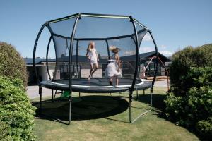 Dwie dziewczyny skaczą na trampolinie. w obiekcie 5 - Delightful Space in Tranquil Neighbourhood, Close to the Lake w mieście Wanaka