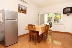 a kitchen and dining room with a table and a refrigerator at Apartments by the sea Zuljana, Peljesac - 10207 in Žuljana