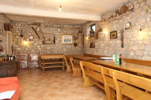 a restaurant with wooden tables and chairs and stone walls at Apartments by the sea Brijesta, Peljesac - 10223 in Brijesta