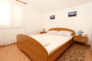 a bedroom with a large bed and a window at Apartments by the sea Brijesta, Peljesac - 10223 in Brijesta