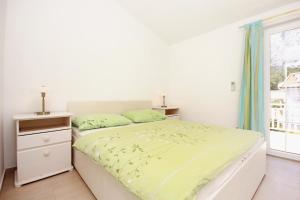 a white bedroom with a bed and a window at Apartments with parking space Orebic, Peljesac - 10173 in Orebić